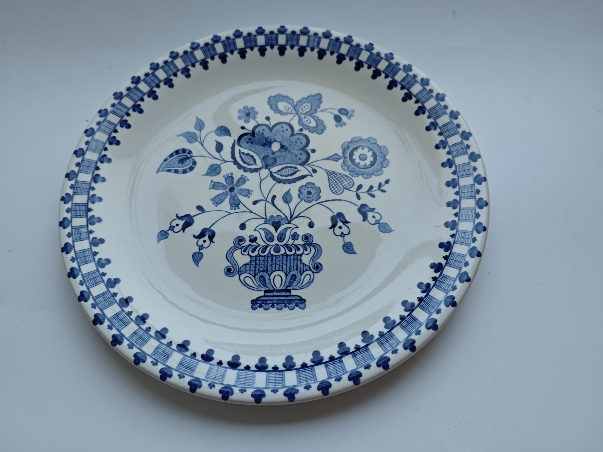 Vintage Johnson Bros “Jamestown” bord, Engeland ca. 1930–1950. Klassiek blauw-wit decor met florale vaas. Old Granite aardewerk. In nette vintage staat. 1 Vintage Johnson Bros “Jamestown” bord, Engeland ca. 1930–1950. Klassiek blauw-wit decor met florale vaas. Old Granite aardewerk. In nette vintage staat.